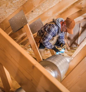 man on attic installing duct
